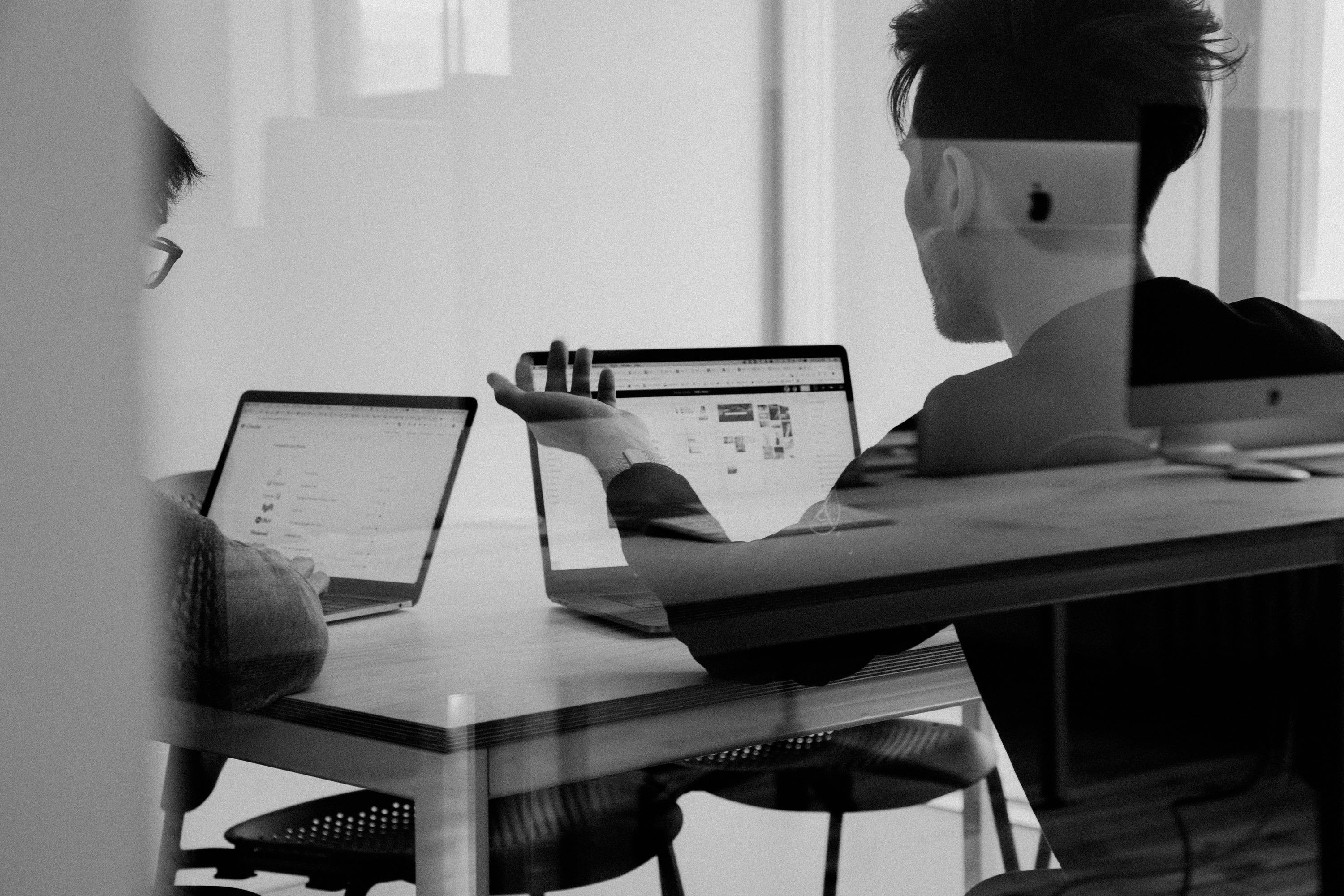 Professionals presenting remotely with laptop in modern conference room